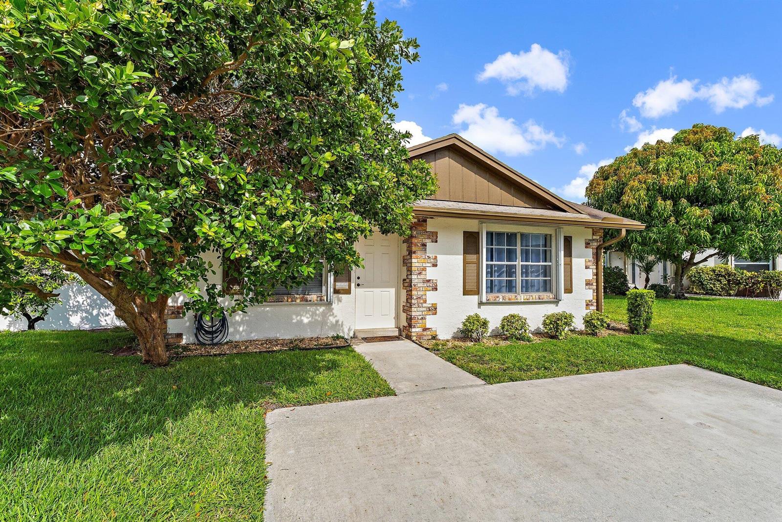 A single-story house with white stucco walls, brick accents, and a concrete driveway — 109 Doe Trail, Jupiter FL 33458, JUPITER, FL