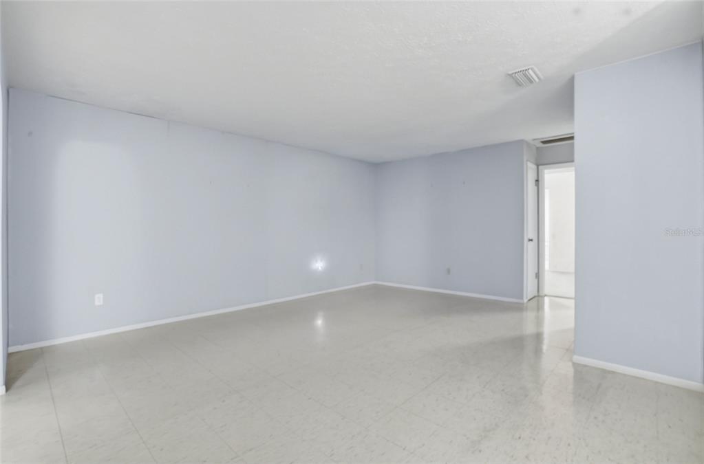 An empty room with light blue walls, white trim, and light-colored tile flooring — 1026 W RAMBLA STREET, TAMPA, FL