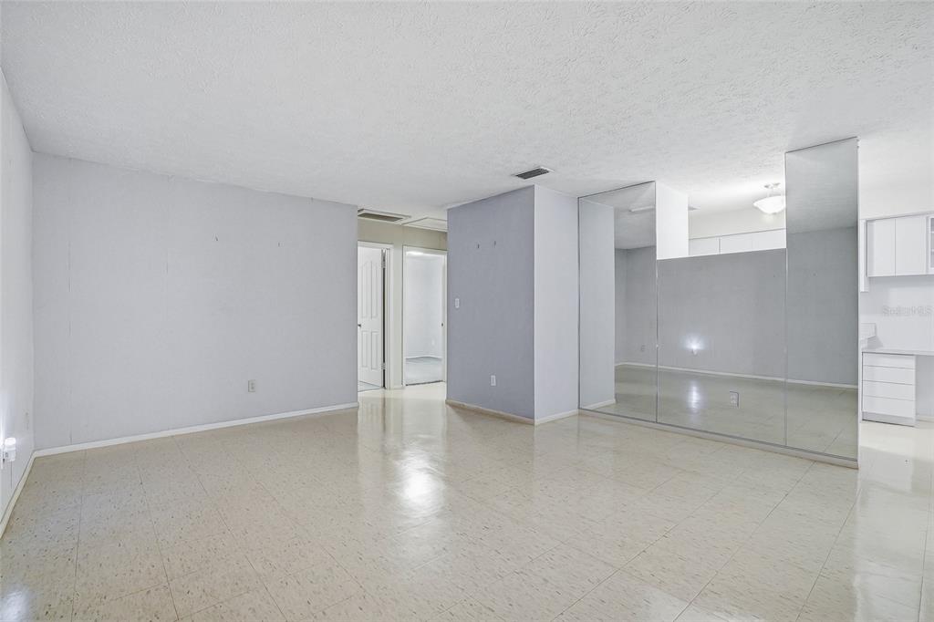 A room with light-colored walls, tiled flooring, and a wall of mirrored closet doors — 1026 W RAMBLA STREET, TAMPA, FL