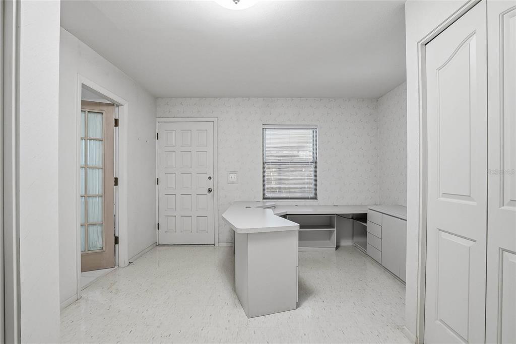 An office room features white walls, a built-in desk, tile flooring, and a white door — 1026 W RAMBLA STREET, TAMPA, FL