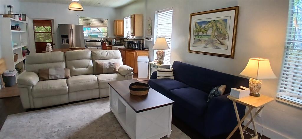 A living room features a white sofa, a blue sofa, and a central coffee table — 1209 BAY PALM BOULEVARD, INDIAN ROCKS BEACH, FL