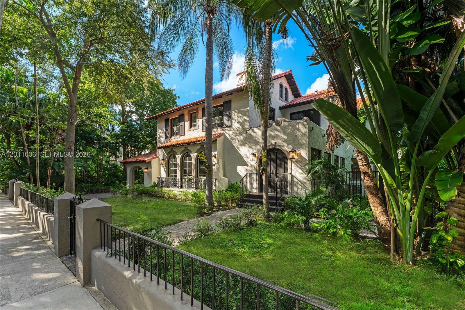 A two-story Mediterranean-style house with a stucco exterior, tile roof, and lush landscaping — 547 NE 57th St, Miami FL 33137, MIAMI, FL