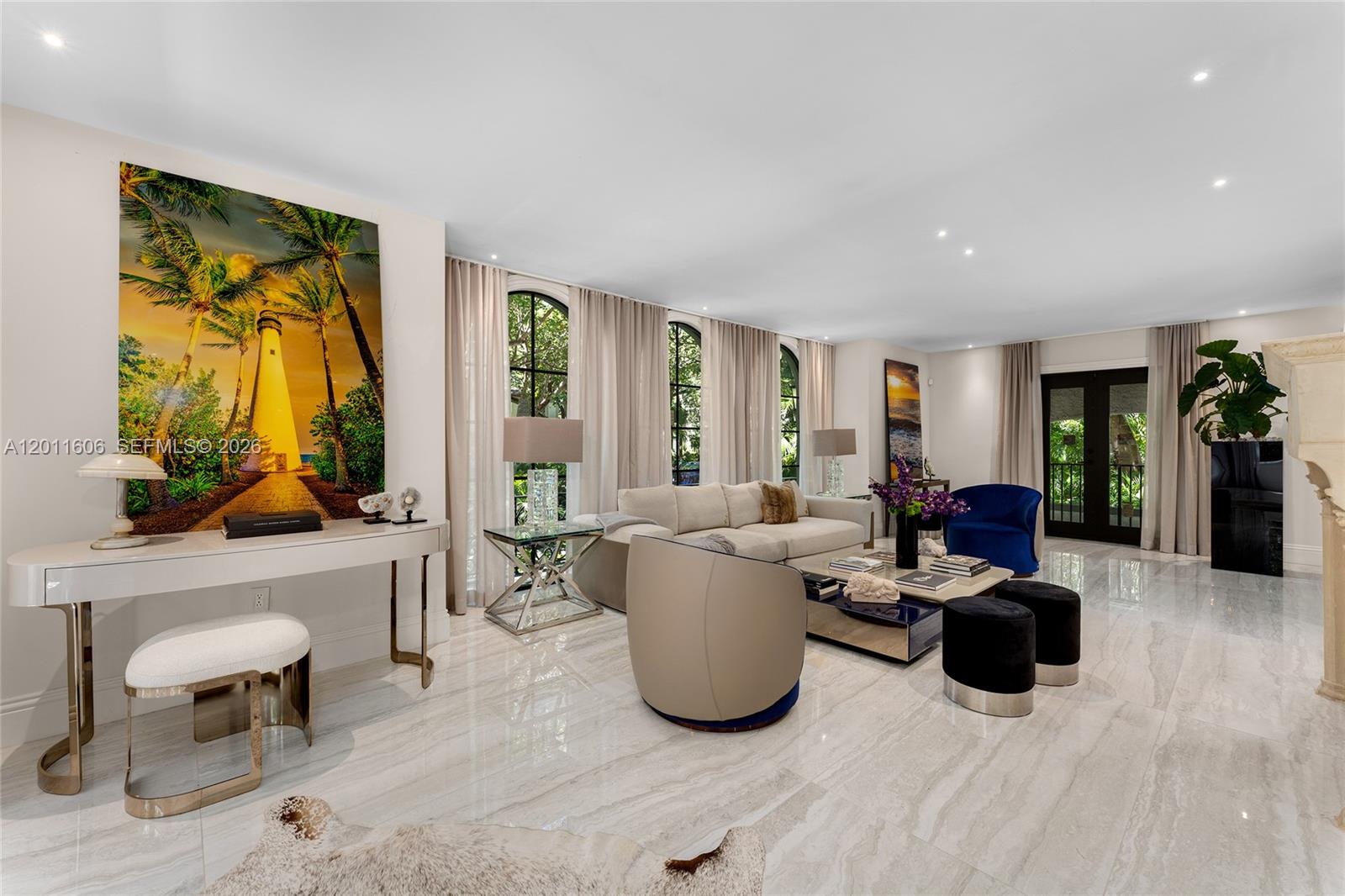 A living room features marble floors, a large lighthouse painting, and neutral-toned furniture — 547 NE 57th St, Miami FL 33137, MIAMI, FL