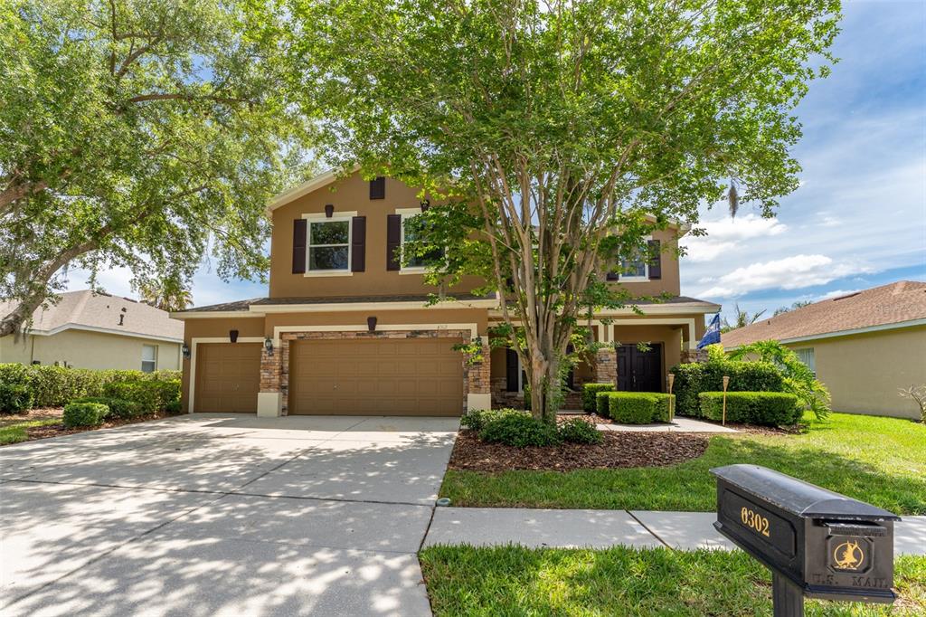 A two-story house with a three-car garage, stone accents, and a mailbox in front — 6302 BRIDGEVISTA DRIVE, LITHIA, FL