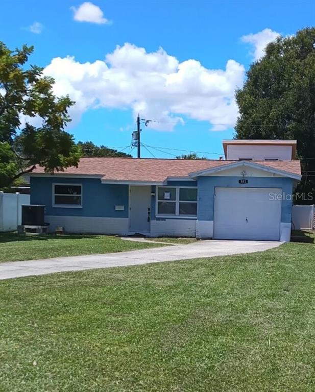 A single-story blue house with a white garage, a concrete driveway, and a front lawn — 501 PALM AVENUE N, ST PETERSBURG, FL