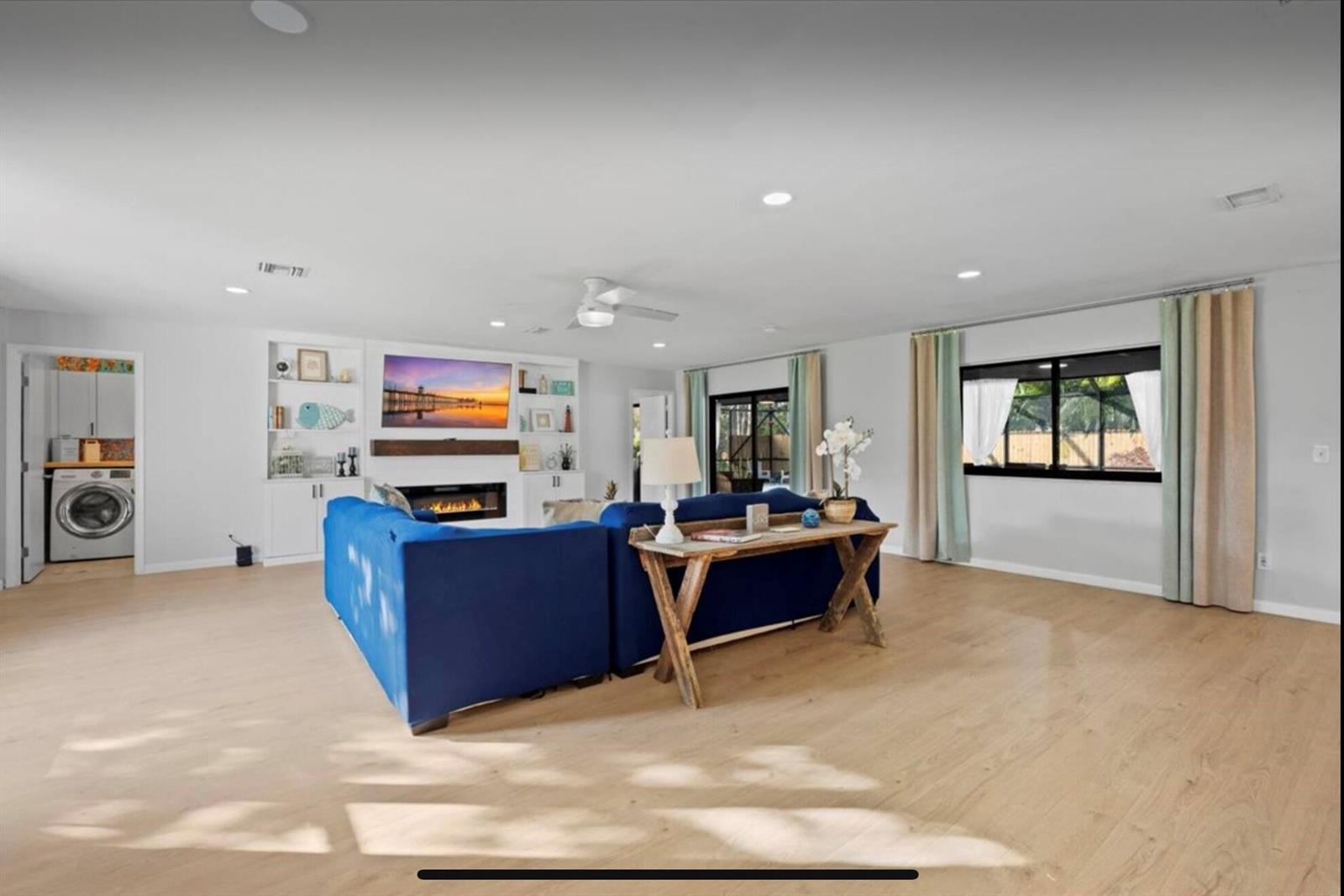 A living room features a blue sectional sofa, a fireplace, and light wood flooring — 11405 N 175th Rd Road N, FL 33478, FL