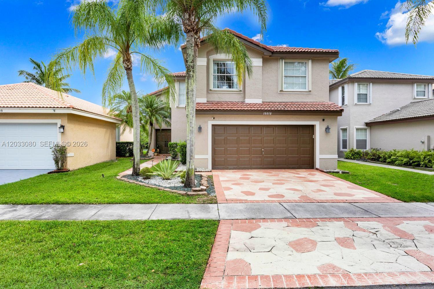A two-story suburban house features a brown garage door and a patterned stone driveway — 18018 SW 30th Ct, Miramar FL 33029, MIRAMAR, FL
