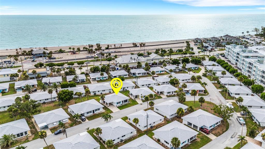 An aerial view shows a residential neighborhood of single-story homes near a beach — 1977 BEACH ROAD UNIT 84, ENGLEWOOD, FL