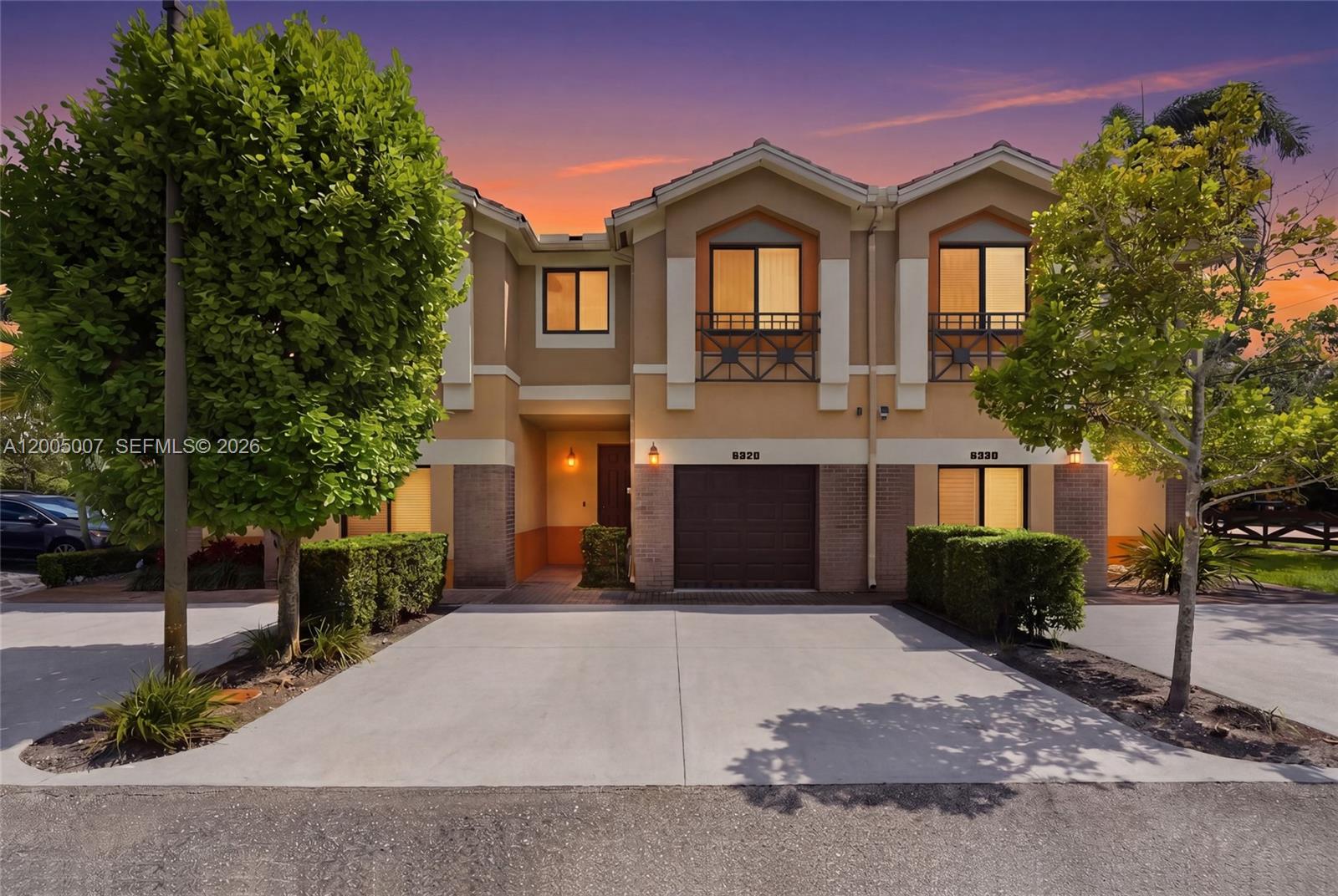 A two-story townhouse exterior features a concrete driveway, a garage, and two upper-level balconies — 6320 S Station Sq, Davie FL 33314, DAVIE, FL