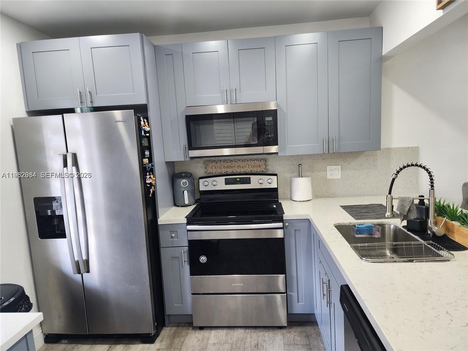 A kitchen features stainless steel appliances, light gray cabinets, and white countertops with a sink — 7605 NW 4th Pl # 206, Margate FL 33063, MARGATE, FL