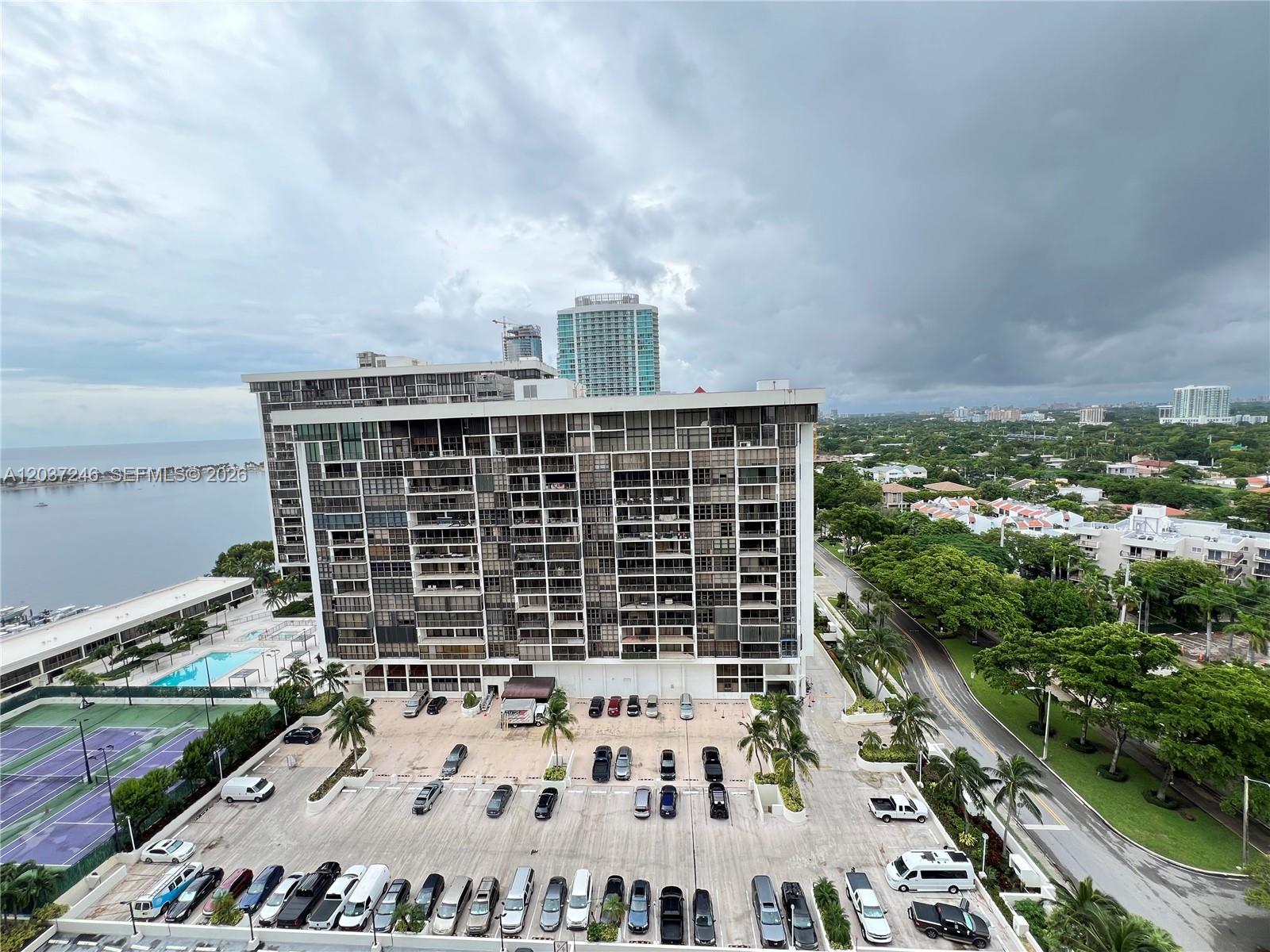 An elevated view shows a large apartment building with a parking lot and tennis courts — 1901 Brickell Ave # B1807, Miami FL 33129, MIAMI, FL