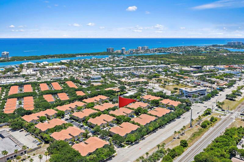 Aerial view of a residential complex with orange-tiled roofs near a coastal town — 114 Lighthouse Circle Unit C, Tequesta FL 33469, TEQUESTA, FL