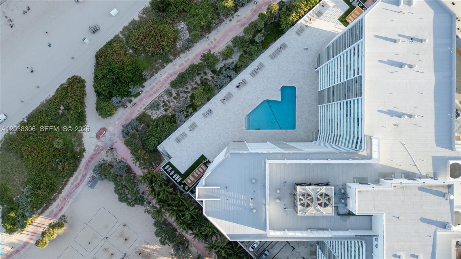 An aerial view shows a high-rise building with a pool deck next to a beach — 7135 Collins Ave # 1216, Miami Beach FL 33141, MIAMI BEACH, FL