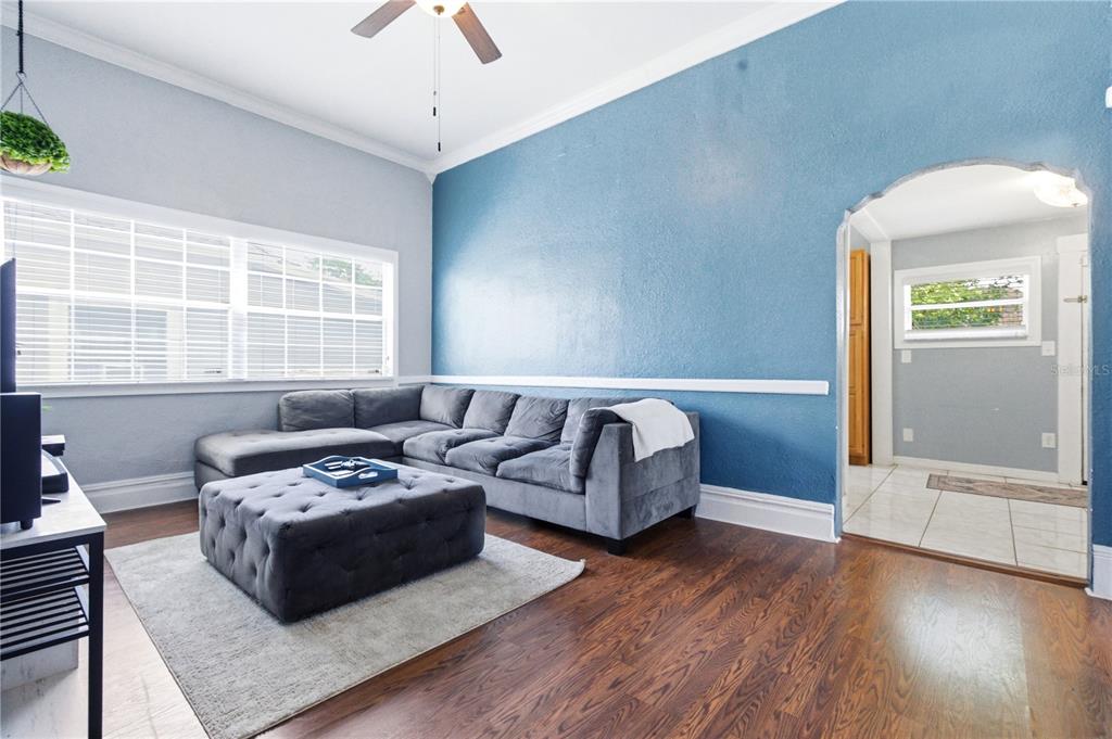 A living room features a grey sectional sofa, a tufted ottoman, and a blue accent wall — 2318 W CORDELIA STREET, TAMPA, FL