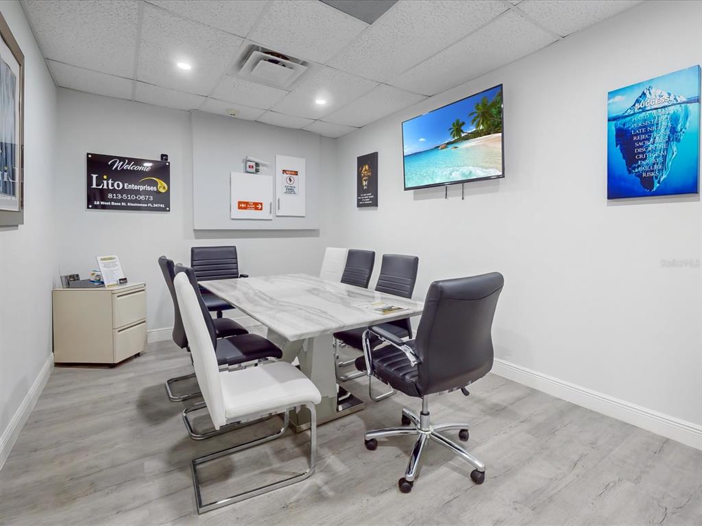 A small conference room features a marble-topped table, six chairs, and a wall-mounted television — 18 W BASS STREET, KISSIMMEE, FL