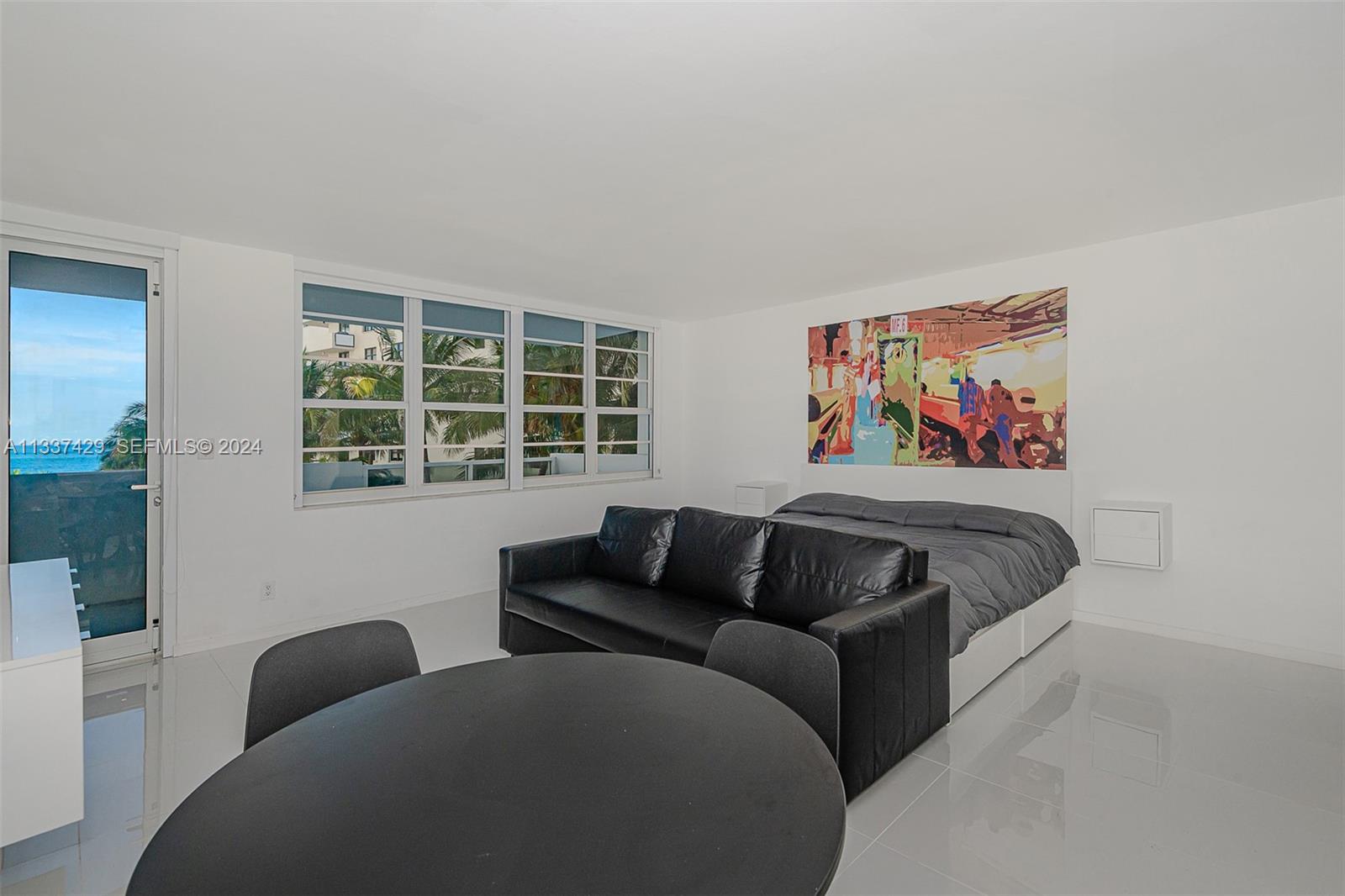 A studio apartment features a black sofa, a bed, a dining table, and ocean views — 100 Lincoln Rd # 519, Miami Beach FL 33139, MIAMI BEACH, FL