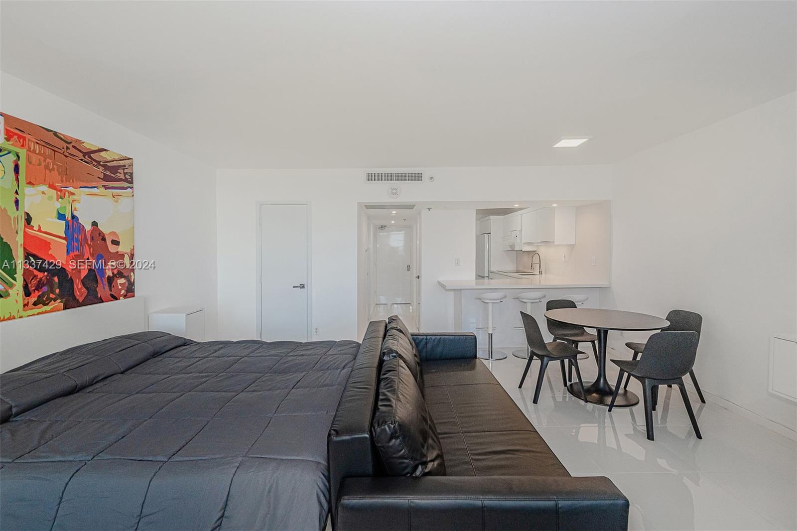 A studio apartment features a bed, a black sofa, a dining table, and a kitchenette — 100 Lincoln Rd # 519, Miami Beach FL 33139, MIAMI BEACH, FL