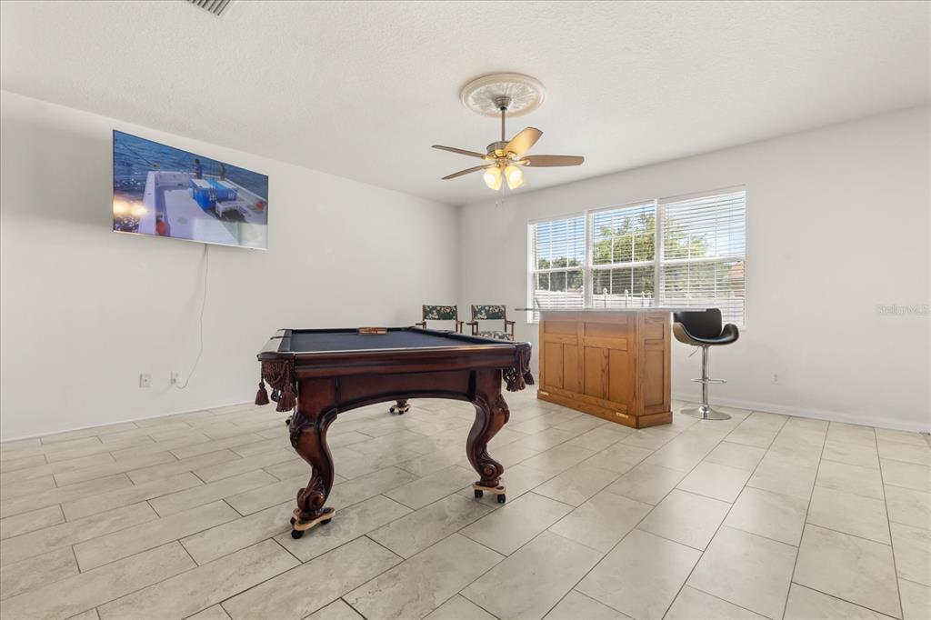 A game room features a pool table, a wooden bar, and a wall-mounted television — 402 CHIMNEY ROCK DRIVE, RUSKIN, FL