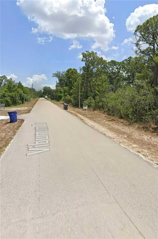 A paved road named Viburnum Drive stretches past wooded areas and residential trash bins — 1224 PASSION FLOWER STREET, SEBRING, FL