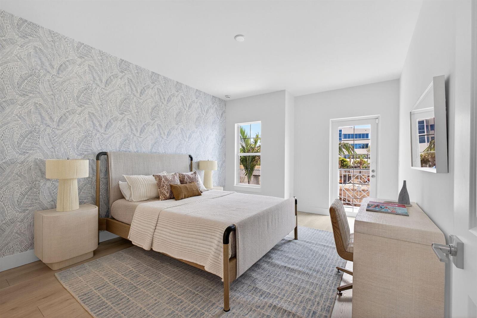 A bedroom features a patterned accent wall, a bed, a desk, and a glass door — 115 Water Pointe Place # 34, Jupiter FL 33477, JUPITER, FL
