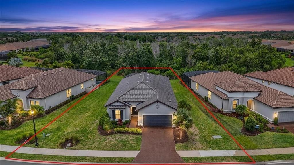 An aerial view of a single-story house with a tiled roof and a paved driveway — 11014 WICKER PARK PLACE, PALMETTO, FL