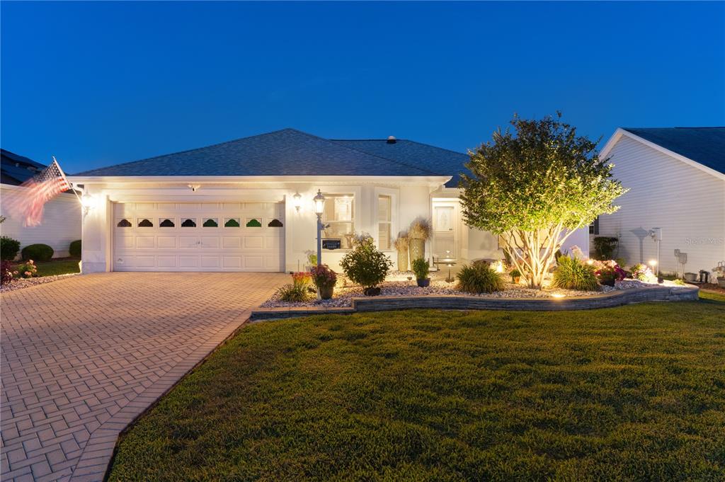 A single-story house with a paved driveway, a two-car garage, and a landscaped front yard — 16689 SE 78TH LIVE OAK AVENUE, THE VILLAGES, FL