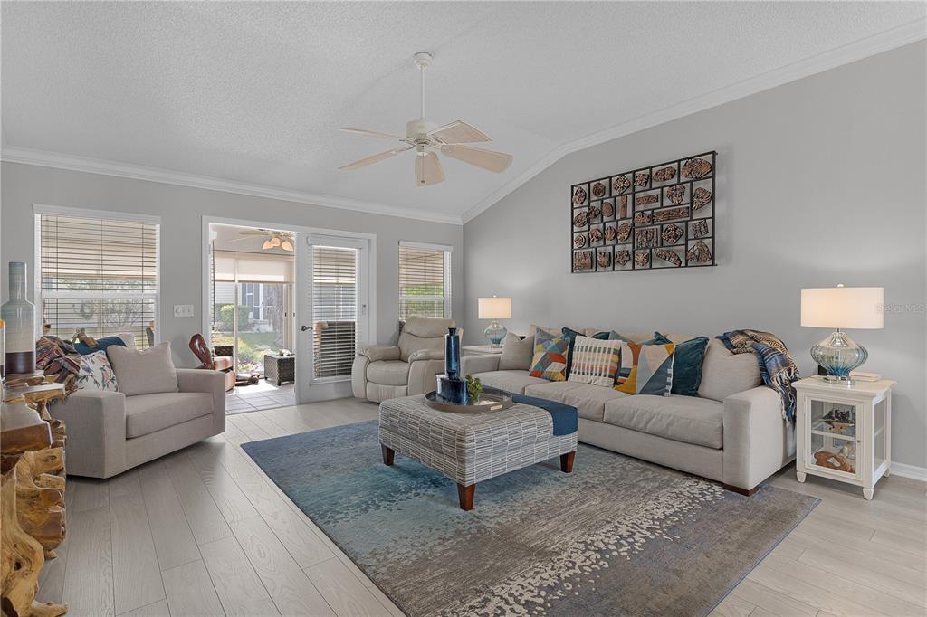 A paved walkway leads to the front entrance of a house with light-colored exterior walls — 16689 SE 78TH LIVE OAK AVENUE, THE VILLAGES, FL