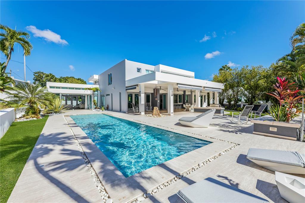 A modern white house features a rectangular swimming pool and a paved patio area — B32 EASTSIDE COURT, GUAYNABO, PR