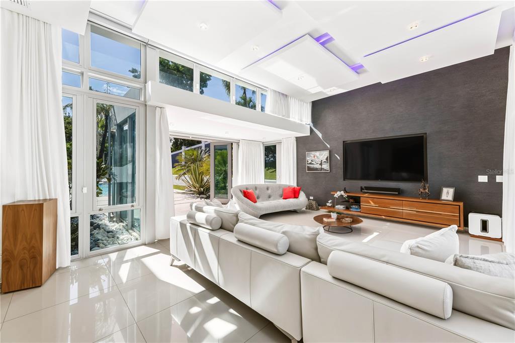 A modern living room features white tile floors, a large sectional sofa, and floor-to-ceiling windows — B32 EASTSIDE COURT, GUAYNABO, PR