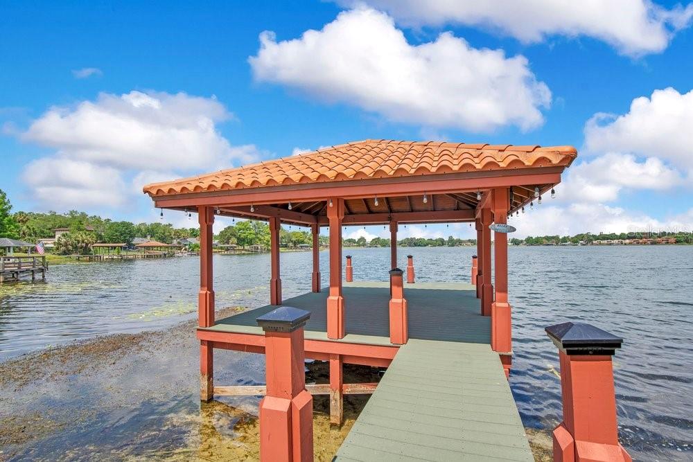 A wooden gazebo with a tiled roof sits at the end of a dock over water — 3108 TROY DRIVE, ORLANDO, FL