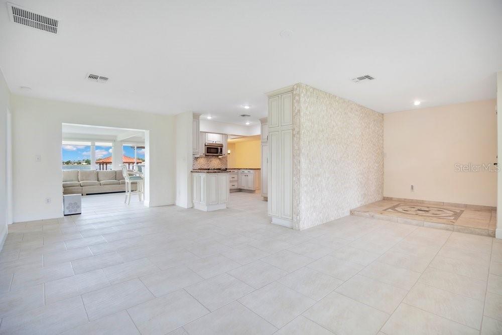 A bright, open-concept living area features light tile flooring, a kitchen, and a sunroom — 3108 TROY DRIVE, ORLANDO, FL