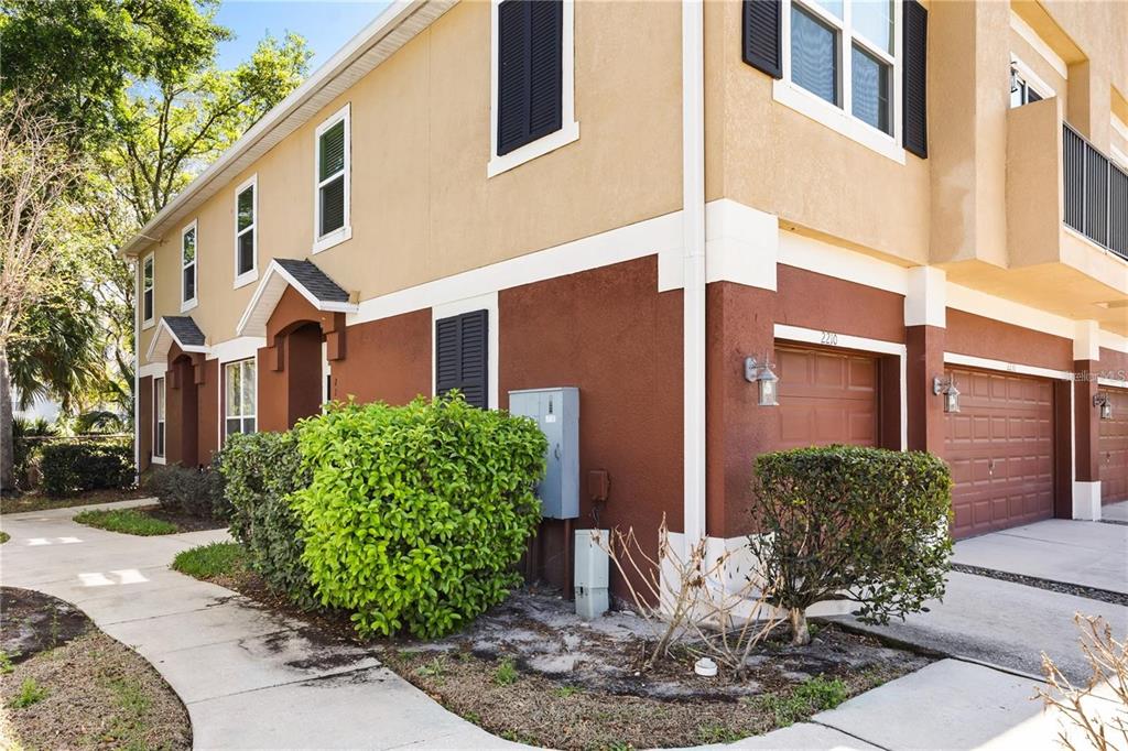 A two-story tan and brown townhouse exterior with a garage and a concrete walkway — 2210 SAN JACINTO CIRCLE, SANFORD, FL