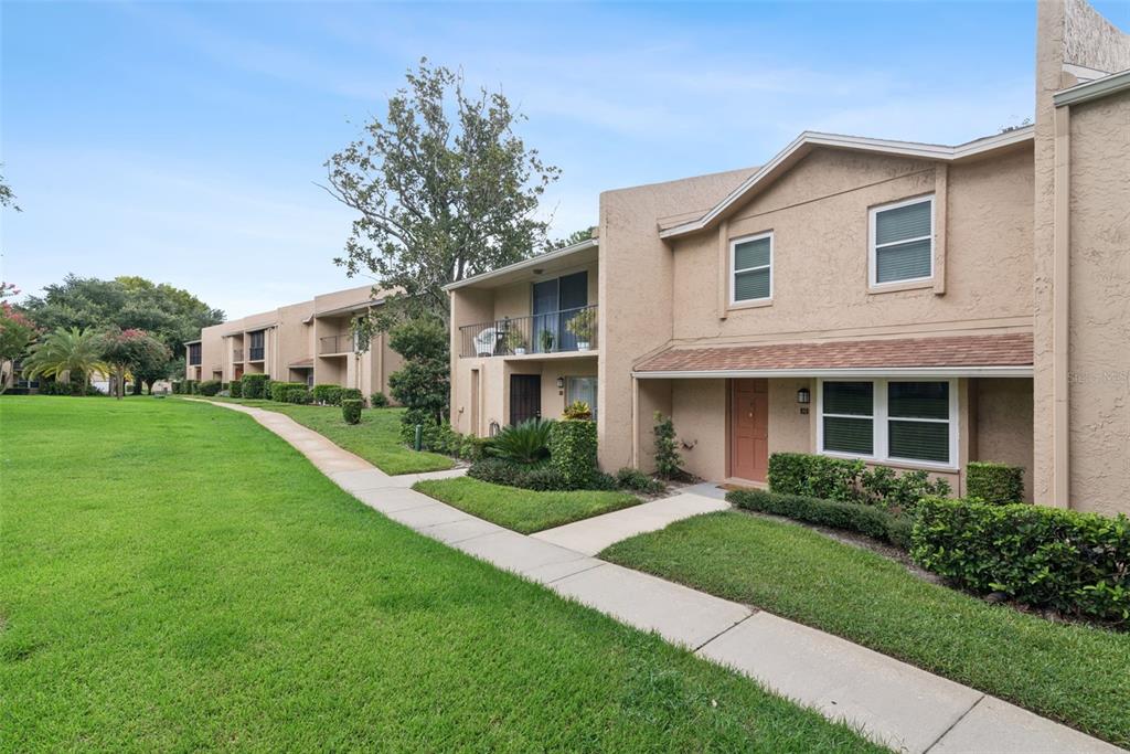 A two-story tan stucco townhouse with a front walkway and a grassy lawn — 820 PARK LAKE CIRCLE UNIT 11, MAITLAND, FL