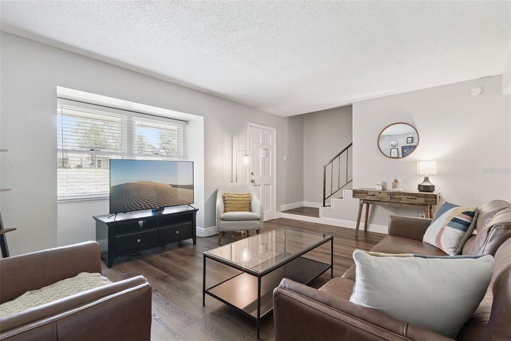 A living room features brown leather furniture, a glass coffee table, and a television console — 820 PARK LAKE CIRCLE UNIT 11, MAITLAND, FL