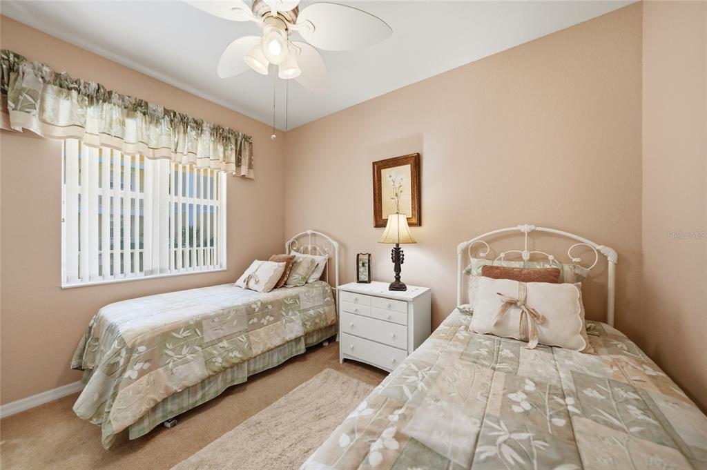 A bedroom features two twin beds with white metal frames, a nightstand, and a window — 255 WEST END DRIVE UNIT 3306, PUNTA GORDA, FL