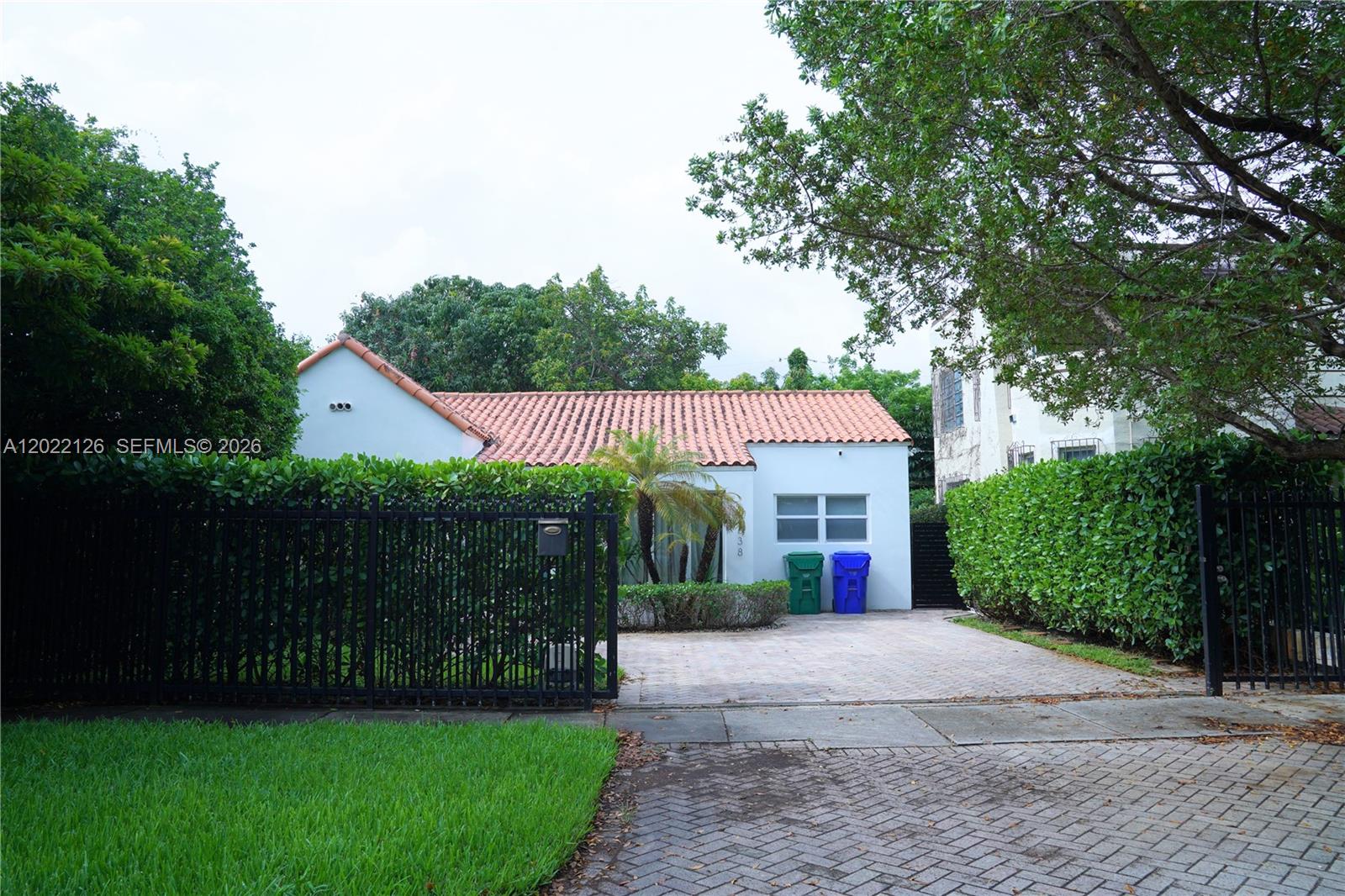 A single-story house with a terracotta tile roof sits behind a black metal fence — 2338 SW 11th St # 2338, Miami FL 33135, MIAMI, FL