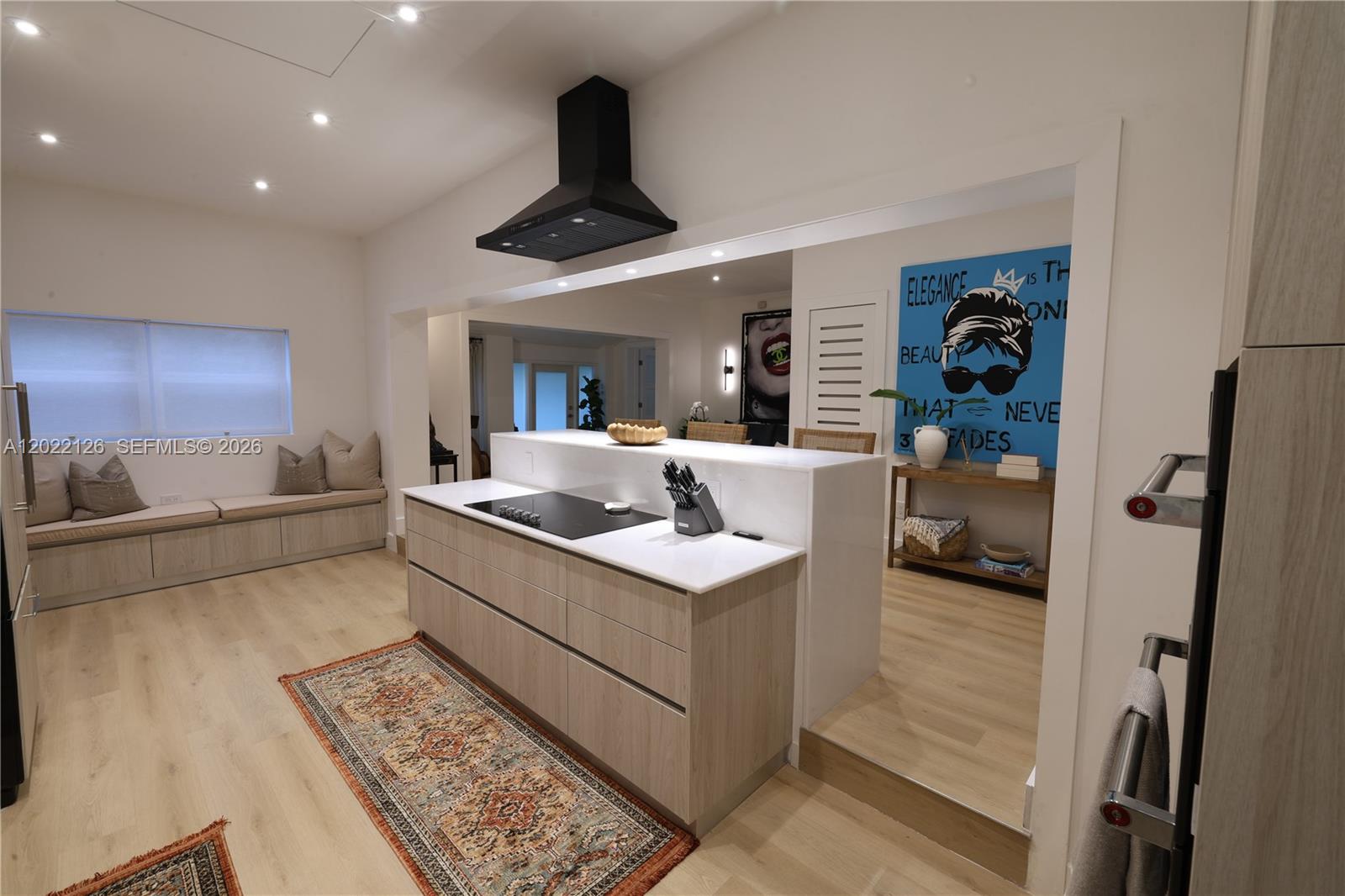 A modern kitchen features a central island with a cooktop and light wood cabinetry — 2338 SW 11th St # 2338, Miami FL 33135, MIAMI, FL