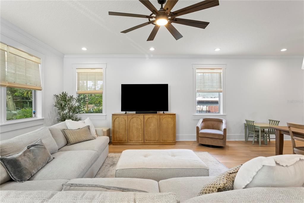 A living room features a large sectional sofa, a television on a wooden console, and windows — 213 W ELM STREET, TAMPA, FL
