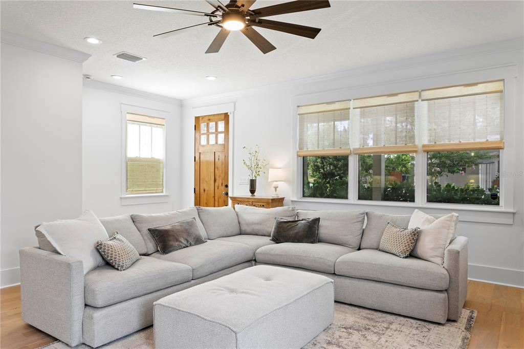 A living room features a large gray sectional sofa, a matching ottoman, and a ceiling fan — 213 W ELM STREET, TAMPA, FL