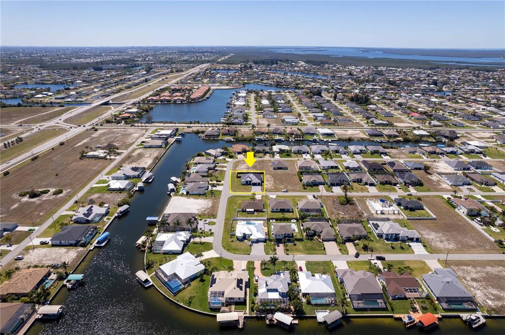 An aerial view shows a residential neighborhood with a highlighted house near a canal — 3300 NW 1ST TERRACE, CAPE CORAL, FL
