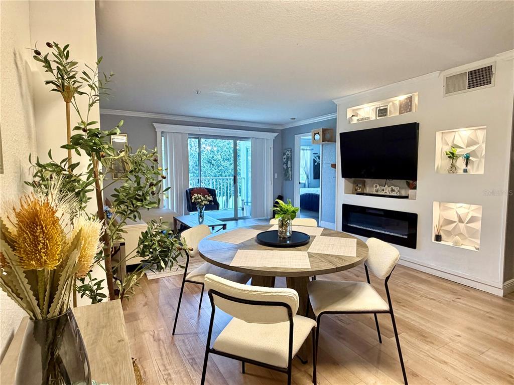 A dining area with a round table and chairs sits before a living room wall — 14049 FAIRWAY ISLAND DRIVE UNIT 124, ORLANDO, FL