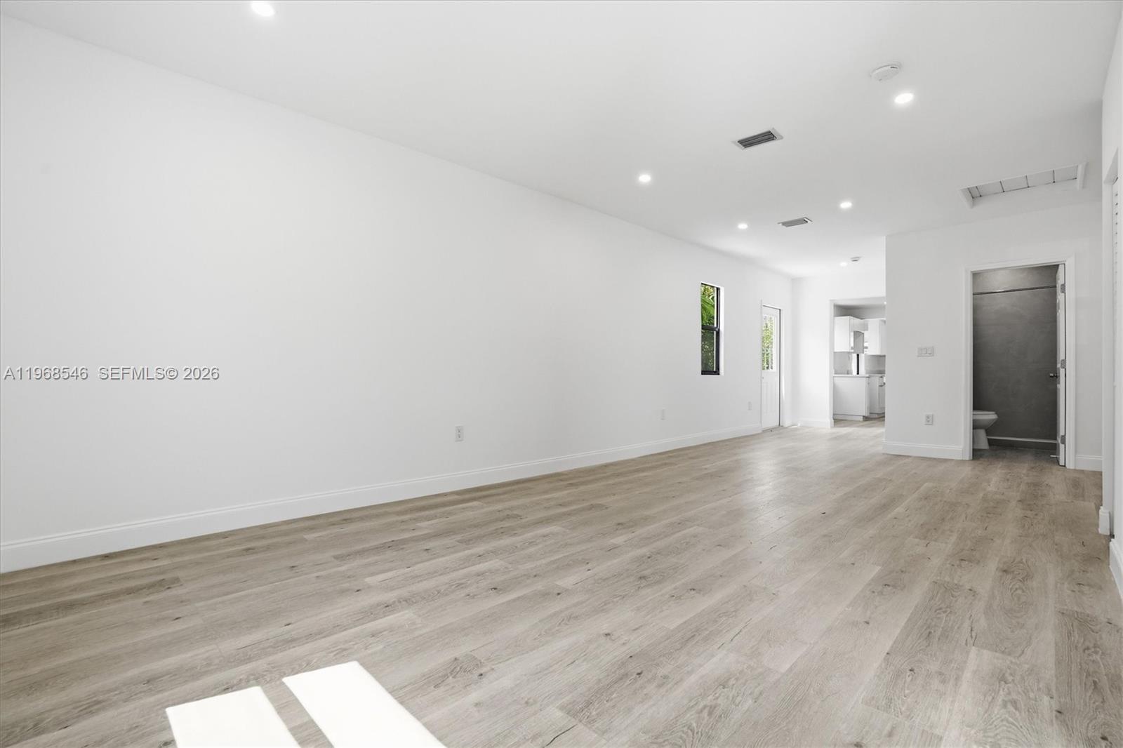 An empty room with white walls, recessed lighting, and light wood-look flooring — 4237 SW 7th St, Miami FL 33134, MIAMI, FL