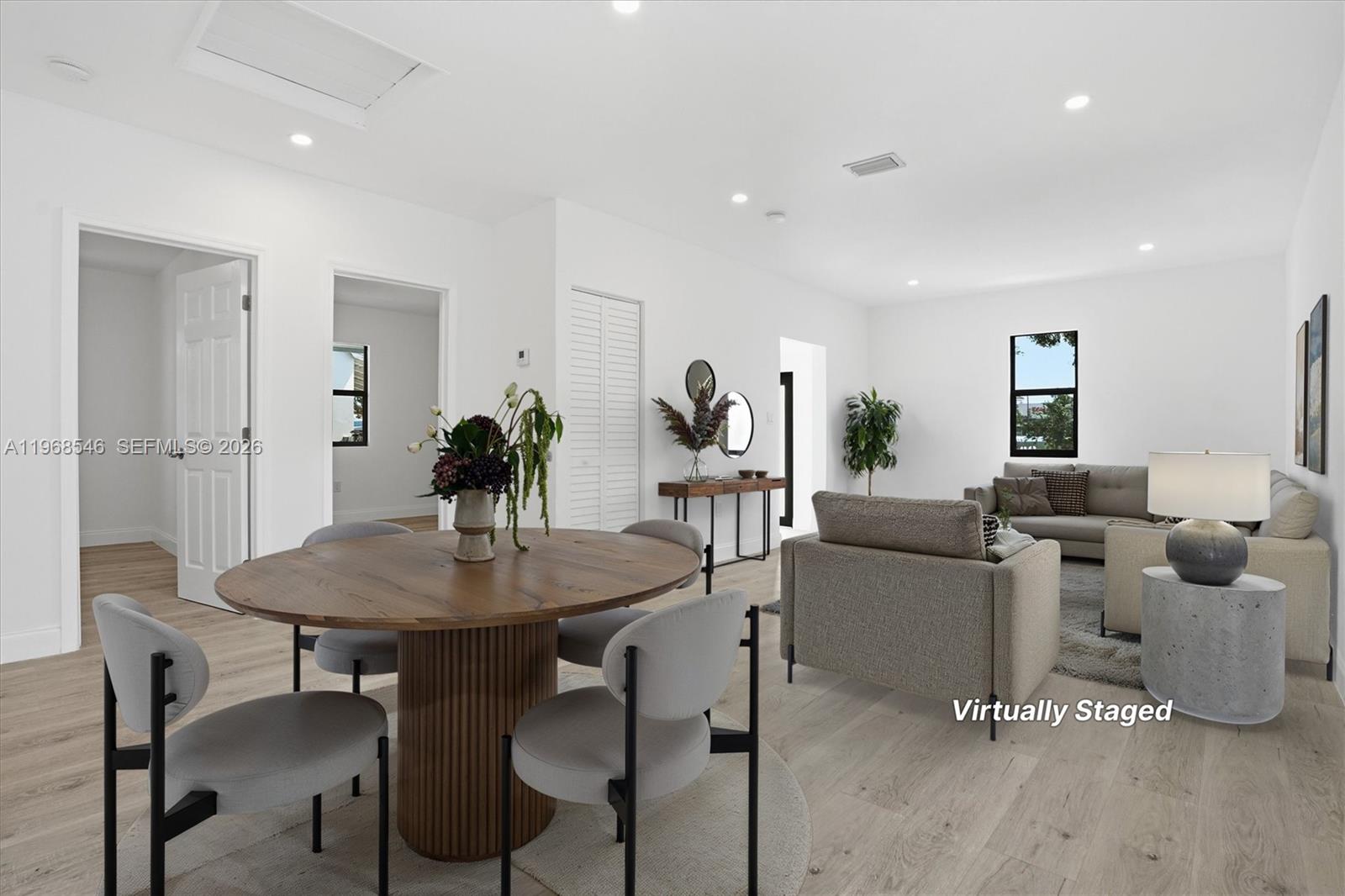 This virtually staged living and dining area features light wood flooring and white walls — 4237 SW 7th St, Miami FL 33134, MIAMI, FL