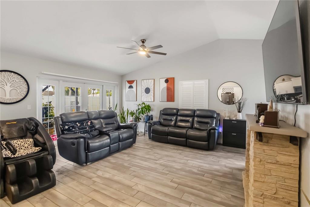 A living room features a stone fireplace, two leather sofas, and a massage chair — 10327 PARKCREST DRIVE, TAMPA, FL