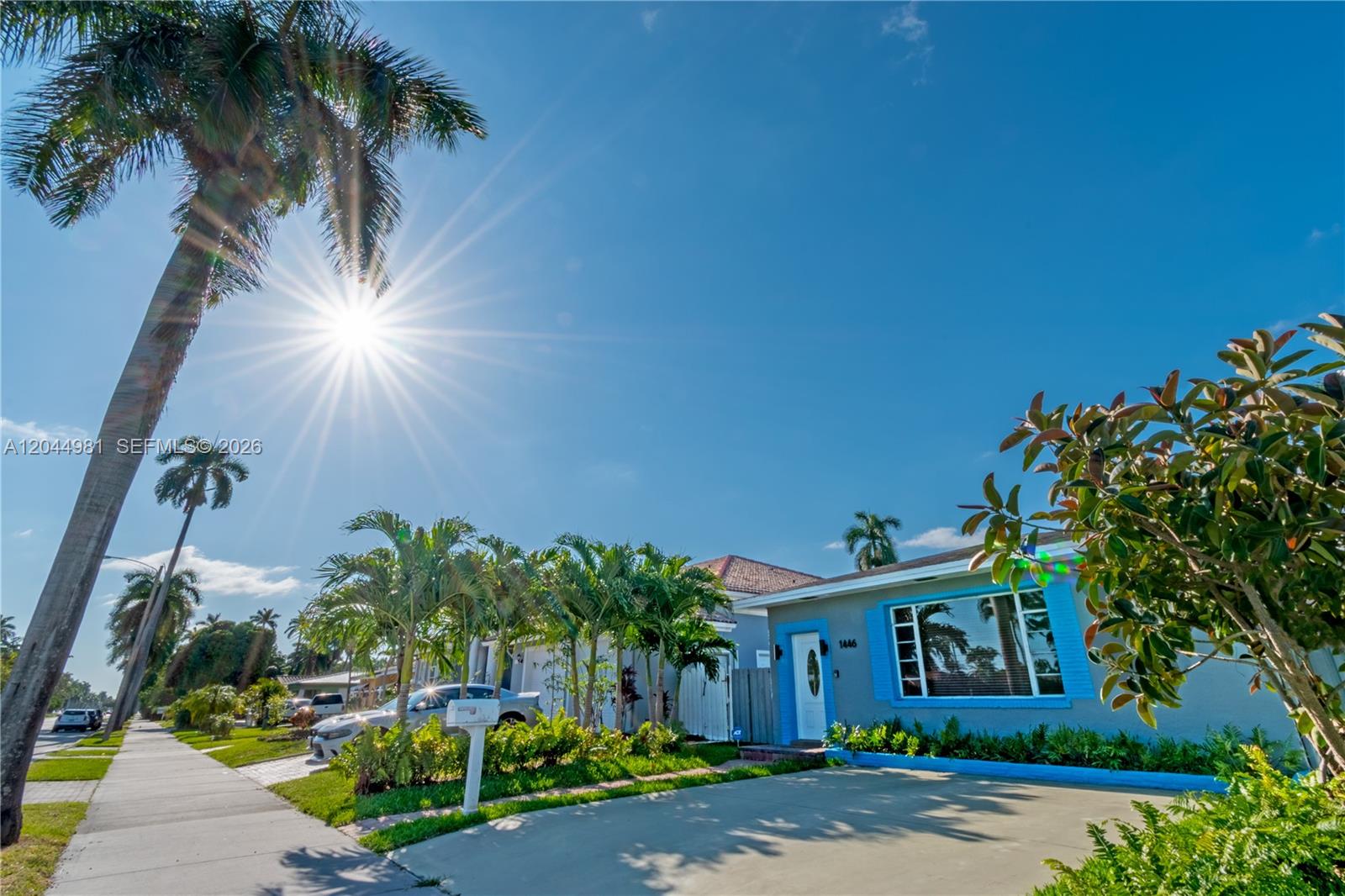 A single-story house with a blue-trimmed window and front door sits under a sunny sky — 1446 Hollywood Blvd, Hollywood FL 33020, HOLLYWOOD, FL
