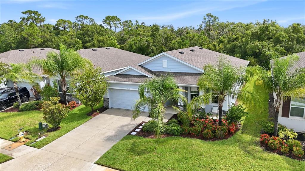 An aerial view of a single-story suburban house with a driveway and palm trees — 13819 CAMDEN CREST TERRACE, LAKEWOOD RANCH, FL