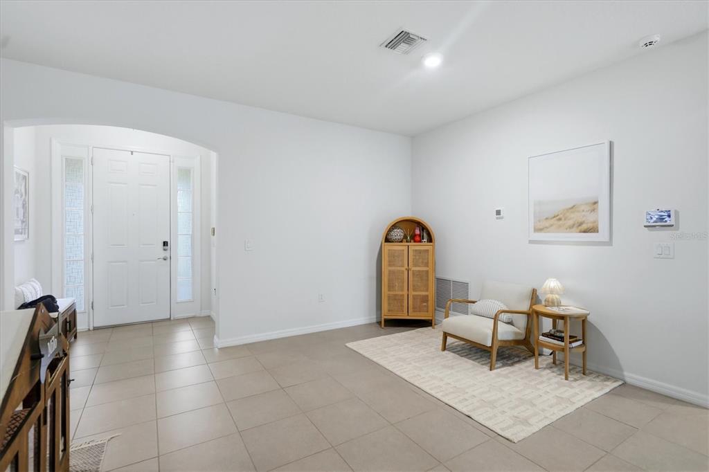 An entryway features light tile flooring, a white front door, and a small seating area — 13819 CAMDEN CREST TERRACE, LAKEWOOD RANCH, FL