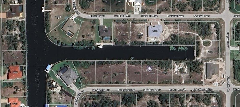 This is an aerial map view of a residential canal-front lot and surrounding properties — 10884 MCALESTER CIRCLE, PORT CHARLOTTE, FL