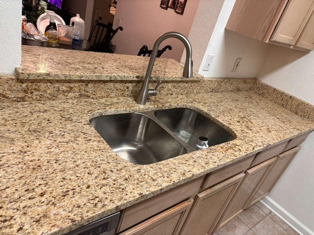 A kitchen sink with a stainless steel faucet is set into a granite countertop — 13524 TURTLE LOOP UNIT 617, ORLANDO, FL