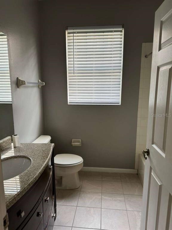 A bathroom with a vanity, toilet, tiled floor, and a window with blinds — 13524 TURTLE LOOP UNIT 617, ORLANDO, FL